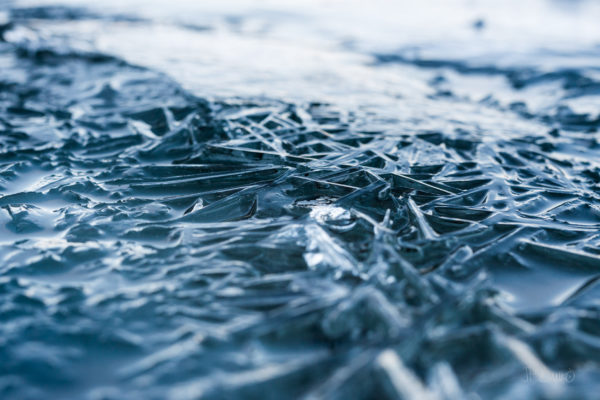 Beautiful otherworldly landscape of blue frozen ice on surface of lake