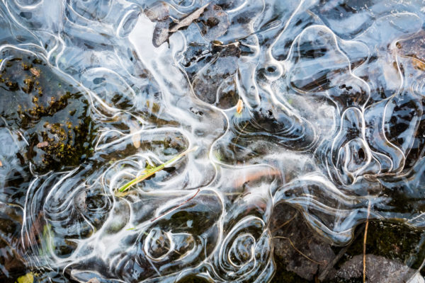 Thin swirling surface ice as spring thaw melts lake